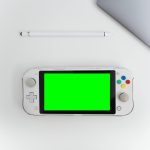 Minimalist top-down view of a Nintendo Switch with green screen and stylus on a white desk.